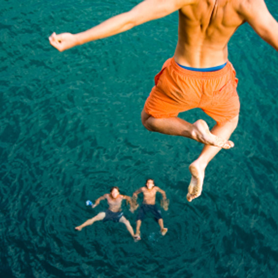 Man cliff jumping into water.